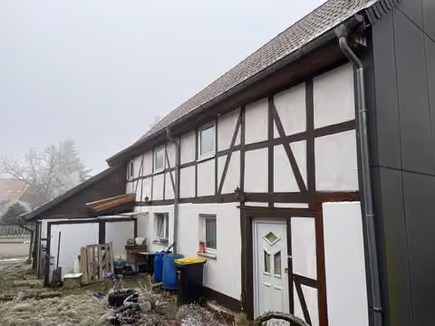 Zwangsversteigerung Einfamilienhaus in Remlingen – Ostansicht des Gebäudes mit Anbau und Straßenfront.