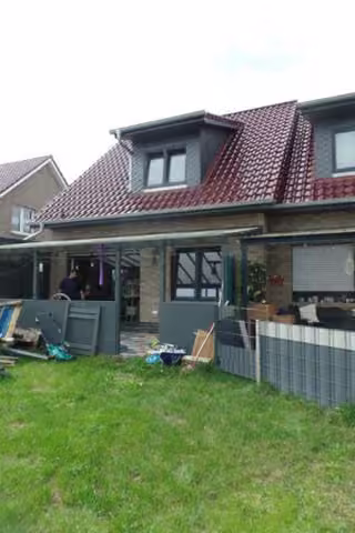 Zwangsversteigerung Doppelhaushälfte in Saterland, Scharrel – Rückansicht des Wohnhauses mit überdachter Terrasse und Garten