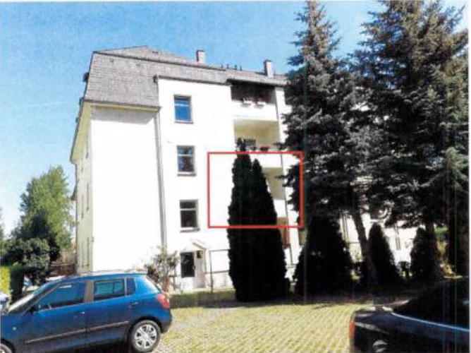 Zwangsversteigerung Eigentumswohnung in Zwickau, Pölbitz – Hofansicht des Mehrfamilienhauses mit Balkonen und Stellplatzbereich.