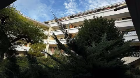 Zwangsversteigerung Eigentumswohnung in Höchberg, Hexenbruch – Ansicht vom begrünten Innenhof (Süd) mit Laubengängen.