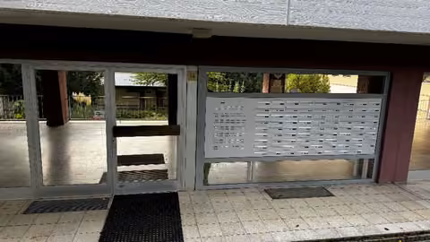 Zwangsversteigerung Eigentumswohnung in Höchberg, Hexenbruch – Hauseingang mit Briefkastenanlage und Klingelboard.