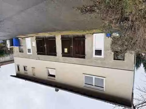 Zwangsversteigerung Einfamilienhaus in Schrecksbach, Röllshausen – Vorderansicht Haus Nr. 4 mit Garagentoren im Untergeschoss.