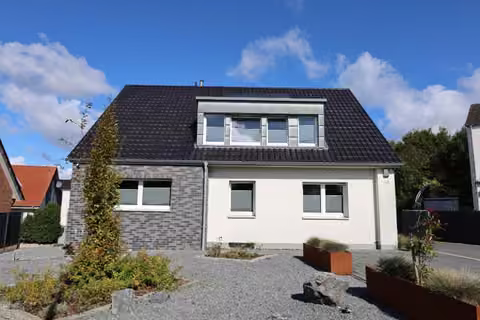 Zwangsversteigerung Einfamilienhaus in Rheine, Dorenkamp – Ansicht von Süden mit Dachgaube, Klinkersockel und Vorgarten.