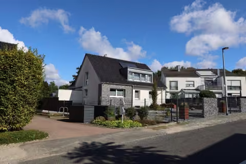 Zwangsversteigerung Einfamilienhaus in Rheine, Dorenkamp – Ansicht von Südwesten mit Gabioneneinfriedung und Nachbarbebauung.