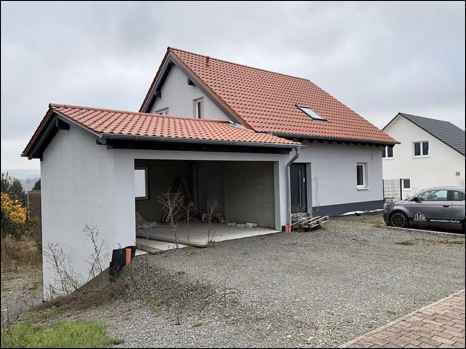 Zwangsversteigerung Einfamilienhaus in Nußbach – Straßenansicht nach Südwesten mit Garage ohne Tore und Satteldach.