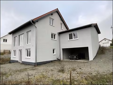 Zwangsversteigerung Einfamilienhaus in Nußbach – Ansicht vom Garten mit rückwärtiger Doppelgarage und Fensterfront.