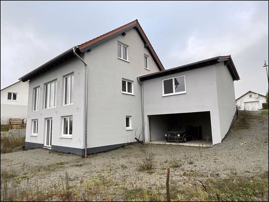 Zwangsversteigerung Einfamilienhaus in Nußbach – Ansicht vom Garten mit rückwärtiger Doppelgarage und Fensterfront.