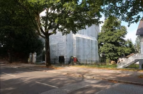 Zwangsversteigerung Mehrfamilienhaus in Bad Segeberg, Klein Niendorf – Seitenansicht des verhüllten Gebäudes mit Baumbestand Blickrichtung Westen.