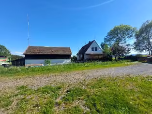 Zwangsversteigerung Einfamilienhaus in Kirchenlamitz, Hohenbuch – Nord-West-Ansicht des Wohnhauses und Nebengebäudes von der Straße aus.