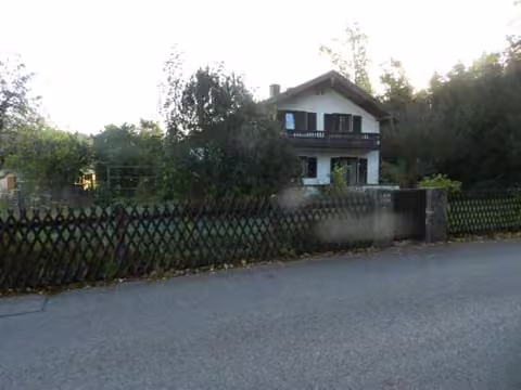 Zwangsversteigerung Grundstück in Stephanskirchen, Haidholzen – Außenansicht des Zweifamilienhauses von Westen über die Walderinger Straße.
