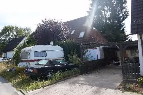 Zwangsversteigerung Einfamilienhaus in Erbach – Straßenansicht westlicher Giebel mit Garagenanbau.