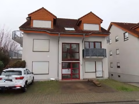 Zwangsversteigerung Eigentumswohnung in Nußloch – Rückansicht des Gebäudes mit Balkonen zur Gartenseite.