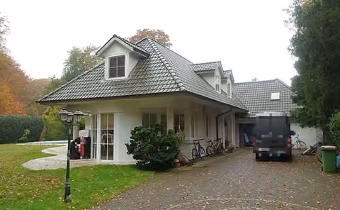 Zwangsversteigerung Einfamilienhaus in Hamburg, Wohldorf-Ohlstedt – Gartenfassade des Einfamilienhauses mit Terrasse, Loggia und parkähnlichem Grundstück.