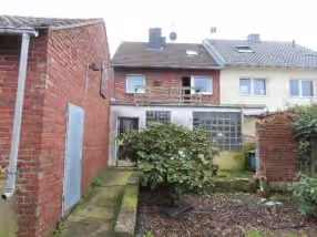 Zwangsversteigerung Doppelhaushälfte in Hückelhoven, Brachelen – Rückansicht des Wohnhauses mit geschlossenem Hof und Gartenbereich.