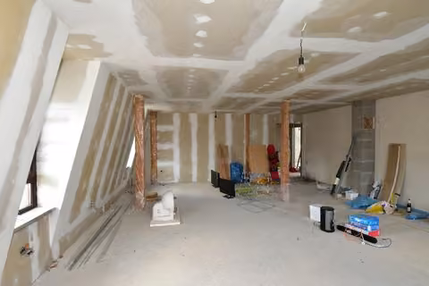 Zwangsversteigerung Eigentumswohnung in Schalkau, Bachfeld – Dachgeschoss mit Wohnzimmerbereich im Ausbauzustand.