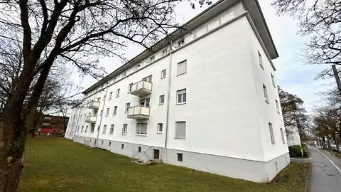 Zwangsversteigerung Eigentumswohnung in Augsburg, Hochfeld – Südansicht des Mehrfamilienhauses Alter Postweg 54a mit Fenstern der Erdgeschosswohnung.