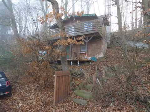 Zwangsversteigerung in Guxhagen, Büchenwerra – Westansicht des Wochenendhauses in Hanglage.
