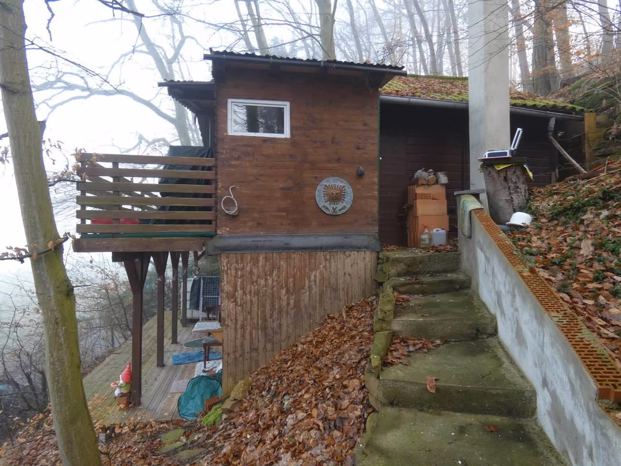 Zwangsversteigerung in Guxhagen, Büchenwerra – Südansicht des Wochenendhauses mit Außentreppe.