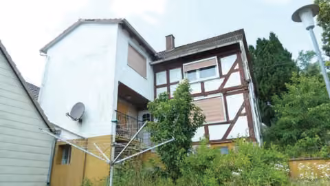 Zwangsversteigerung Einfamilienhaus in Breitenbach am Herzberg, Machtlos – Vorderansicht des Einfamilienhauses mit Fachwerkobergeschoss und massivem Anbau.
