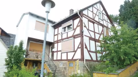 Zwangsversteigerung Einfamilienhaus in Breitenbach am Herzberg, Machtlos – Straßenseitige Ansicht des Gebäudes mit Eingangstreppe und Hanglage.