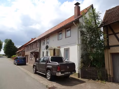 Zwangsversteigerung Einfamilienhaus in Einbeck, Sülbeck – Nordgiebel des Wohnhauses mit Zufahrt zur Garage.