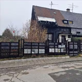 Zwangsversteigerung Doppelhaushälfte in Mülheim an der Ruhr, Altstadt I – Straßenansicht der Doppelhaushälfte mit Einfriedung und Vorgartenbereich.