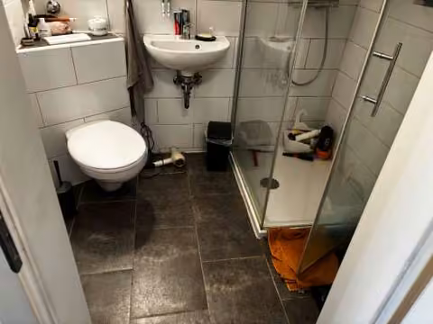 Zwangsversteigerung Eigentumswohnung in Dortmund, Eving – Modernisiertes Badezimmer mit wandhängendem WC und Dusche.