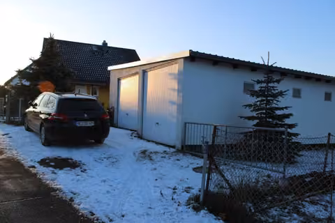 Zwangsversteigerung in Ottendorf-Okrilla, Medingen – Außenansicht des Wochenendhauses mit Wintergarten im Schnee.