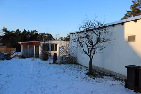 Zwangsversteigerung in Ottendorf-Okrilla, Medingen – Ansicht der Garagensüdseite und Übergang zum Nachbargrundstück.