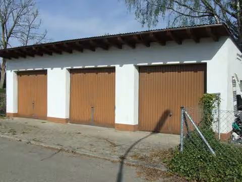 Zwangsversteigerung Doppelhaushälfte in Freising, Attaching – Frontansicht der freistehenden 3-fach Garage mit Toren.