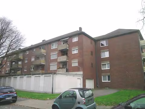 Zwangsversteigerung Eigentumswohnung in Düsseldorf, Unterrath – Außenansicht des Mehrfamilienhauses von der Ziegelstraße mit Garagengeschoss.