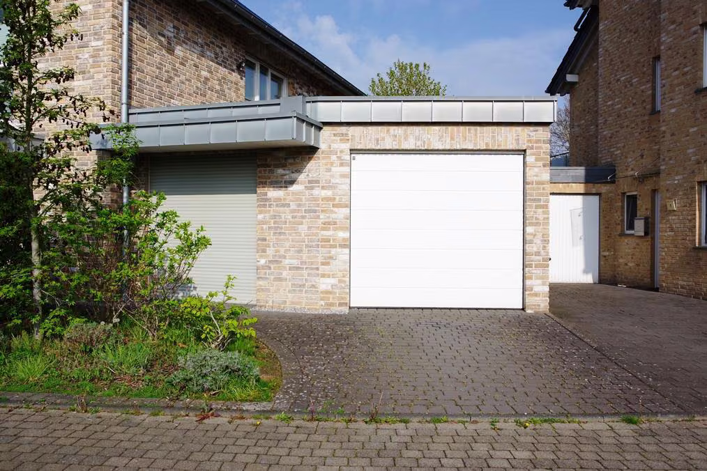 Zwangsversteigerung Einfamilienhaus in Jüchen, Otzenrath – Detailansicht der rechten Garage mit Zufahrt.