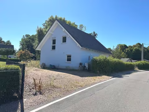 Zwangsversteigerung Einfamilienhaus in Hainichen, Berthelsdorf – Straßenansicht mit Grundstückszufahrt und nördlicher Giebelseite.