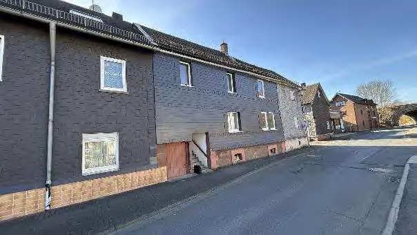 Zwangsversteigerung Einfamilienhaus in Haiger – Perspektivische Außenansicht der Straßenfassade und Nachbarbebauung.