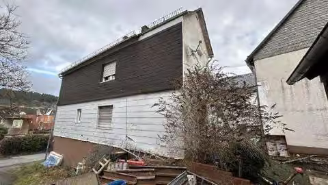 Zwangsversteigerung Einfamilienhaus in Eschenburg, Simmersbach – Rückseitige Ansicht des Wohnhauses und Dachbereichs.