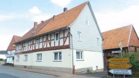Zwangsversteigerung Doppelhaushälfte in Cornberg, Rockensüß – Straßenseitige Fassadenansicht der Doppelhaushälfte mit Fachwerkobergeschoss.