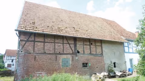 Zwangsversteigerung Doppelhaushälfte in Cornberg, Rockensüß – Fachwerkscheune und Nebengebäude von der Hofseite.