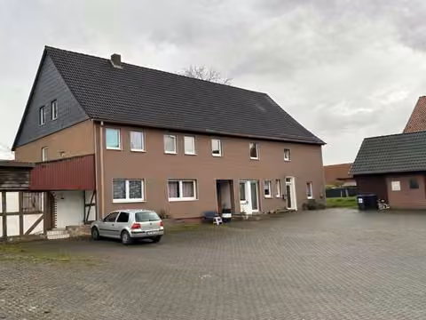 Zwangsversteigerung Mehrfamilienhaus in Einbeck, Holtensen – Vorderansicht des Mehrfamilienhauses von Nordwesten mit Hoffläche.