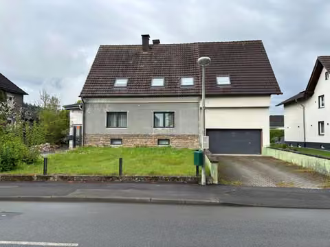 Zwangsversteigerung Zweifamilienhaus in Neuenrade, Küntrop – Vorderansicht des Ein- bis Zweifamilienhauses mit Doppelgarage von der Straßenseite.