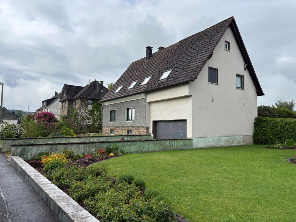 Zwangsversteigerung Zweifamilienhaus in Neuenrade, Küntrop – Rechte Seitenansicht des Gebäudes mit Gartenbereich.