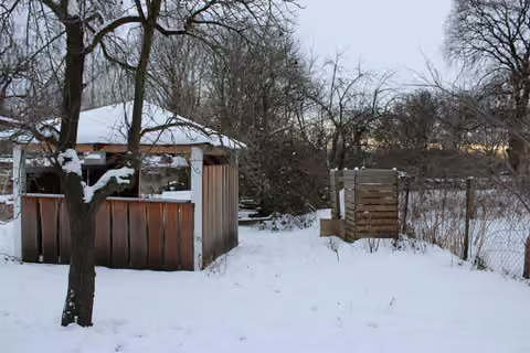 Zwangsversteigerung Landwirtschaft in Weißenberg, Belgern – Südlicher Grundstücksbereich mit hölzernem Unterstand im Schnee.