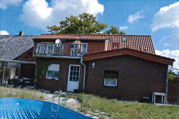 Zwangsversteigerung Einfamilienhaus in Karstädt – Rückwärtige Gebäudeansicht mit Anbau und Nebengelass.