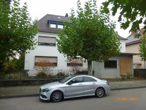 Zwangsversteigerung Einfamilienhaus in Mörfelden-Walldorf, Walldorf – Vorderansicht des Wohnhauses von Süden mit Vorgarten und Straße.