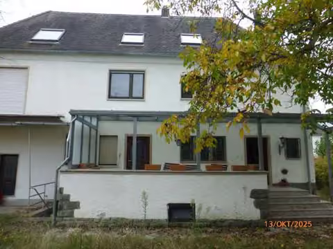 Zwangsversteigerung Einfamilienhaus in Mörfelden-Walldorf, Walldorf – Rückansicht des Wohnhauses von Norden mit überdachter Terrasse.