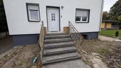 Zwangsversteigerung Eigentumswohnung in Driedorf – Eingangsbereich mit Vortreppe des Wohnhauses.