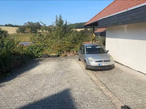 Zwangsversteigerung Grundstück in Idstein, Heftrich – Ansicht des Grundstücks von Osten aus dem Kilbachweg mit befestigter Stellplatzfläche.