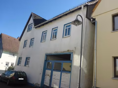 Zwangsversteigerung Einfamilienhaus in Usingen, Wernborn – Schrägansicht des Gebäudes von Südwesten entlang der Kirchstraße.