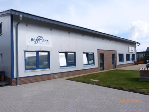 Zwangsversteigerung Grundstück in Neuenkirchen-Vörden, Hörsten – Vorderansicht der Gewerbehalle mit Zufahrt und Eingangsbereich.