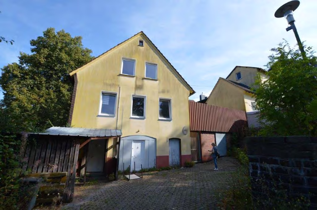 Zwangsversteigerung Wohn-/Geschäftshaus in Lüdenscheid – Vorderansicht Hausnummer 6 mit Zufahrt und Nebengebäuden.
