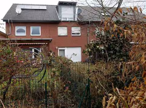 Zwangsversteigerung Reihenhaus in Wesseling, Keldenich – Rückansicht des Wohnhauses mit Gaube und angrenzendem Gartenbereich.